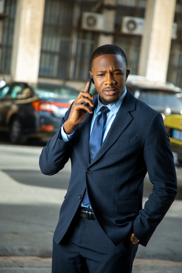 Confident businessman in formal attire making a phone call outdoors in Dakar, Senegal.